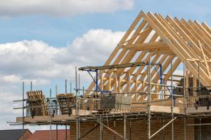 Timber framework of house roof trusses with scaffold on a building being built on a new housing estate